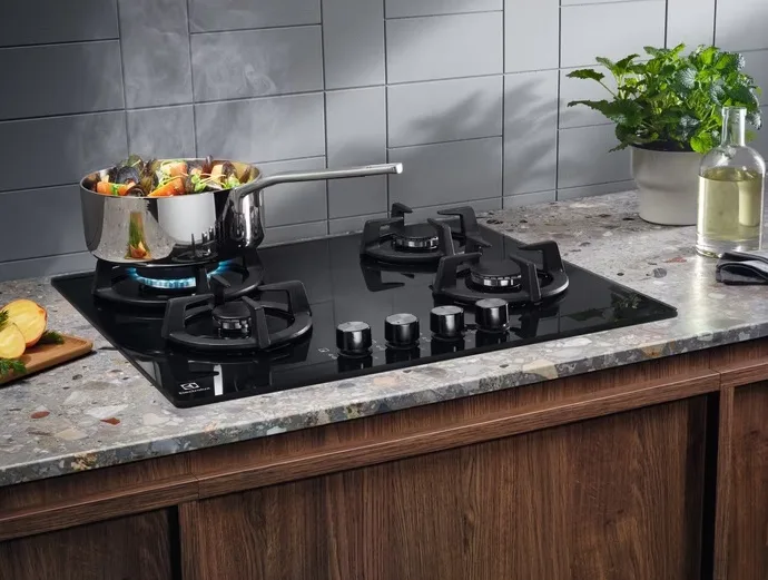 Газова варильна поверхня Electrolux на скляній основі, 60 см, з чавунними решітками, чорного кольору.